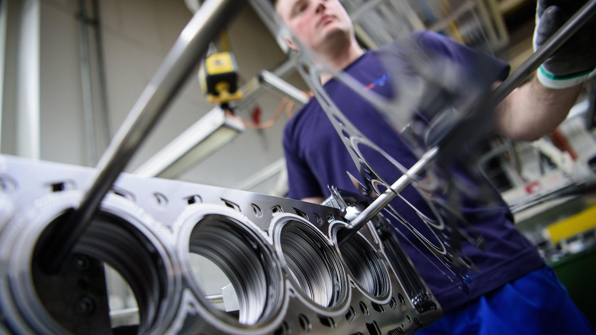 ARCHIV - 26.03.2018, Baden-Württemberg, Dettingen an der Erms: Ein Mitarbeiter eines Autozulieferers kontrolliert die Produktion der Zylinderkopfdichtungen. (zu dpa: «Branchenexperten: Luft für deutsche Autozulieferer wird dünner») Foto: Sina Schuldt/dpa +++ dpa-Bildfunk +++