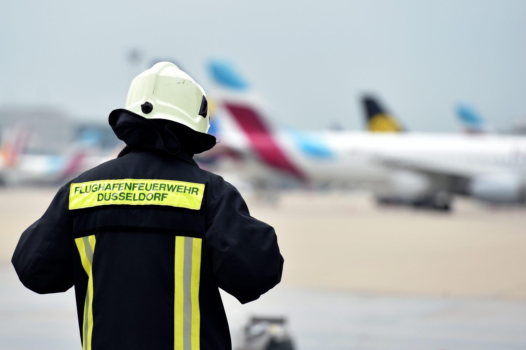 Ein Mitarbeiter der Flughafenfeuerwehr auf dem Rollfeld des Flughafens in Düsseldorf (Nordrhein-Westfalen).