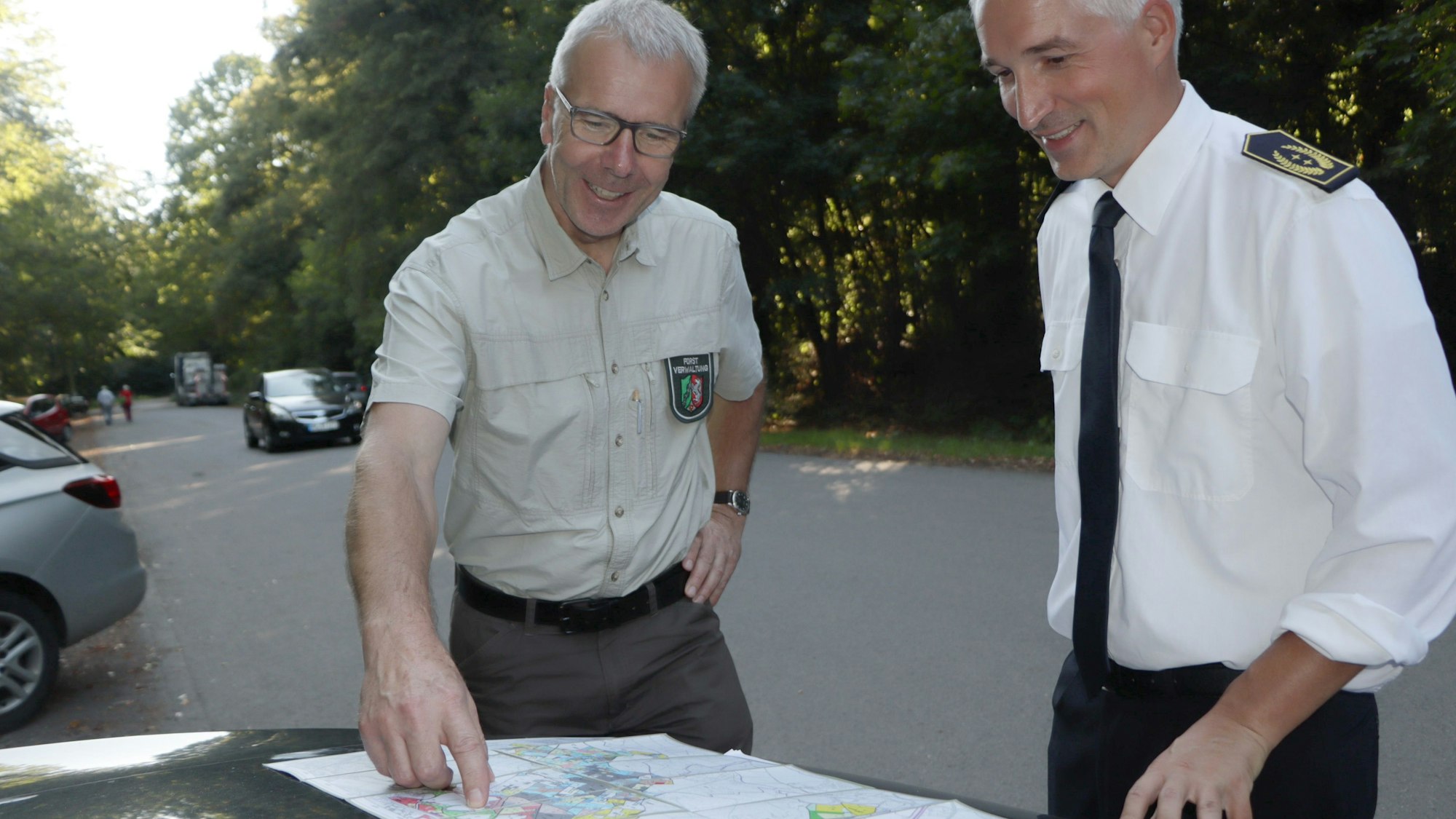 Auf dem Bild sind zwei Männer zu sehen, die eine Karte studieren.