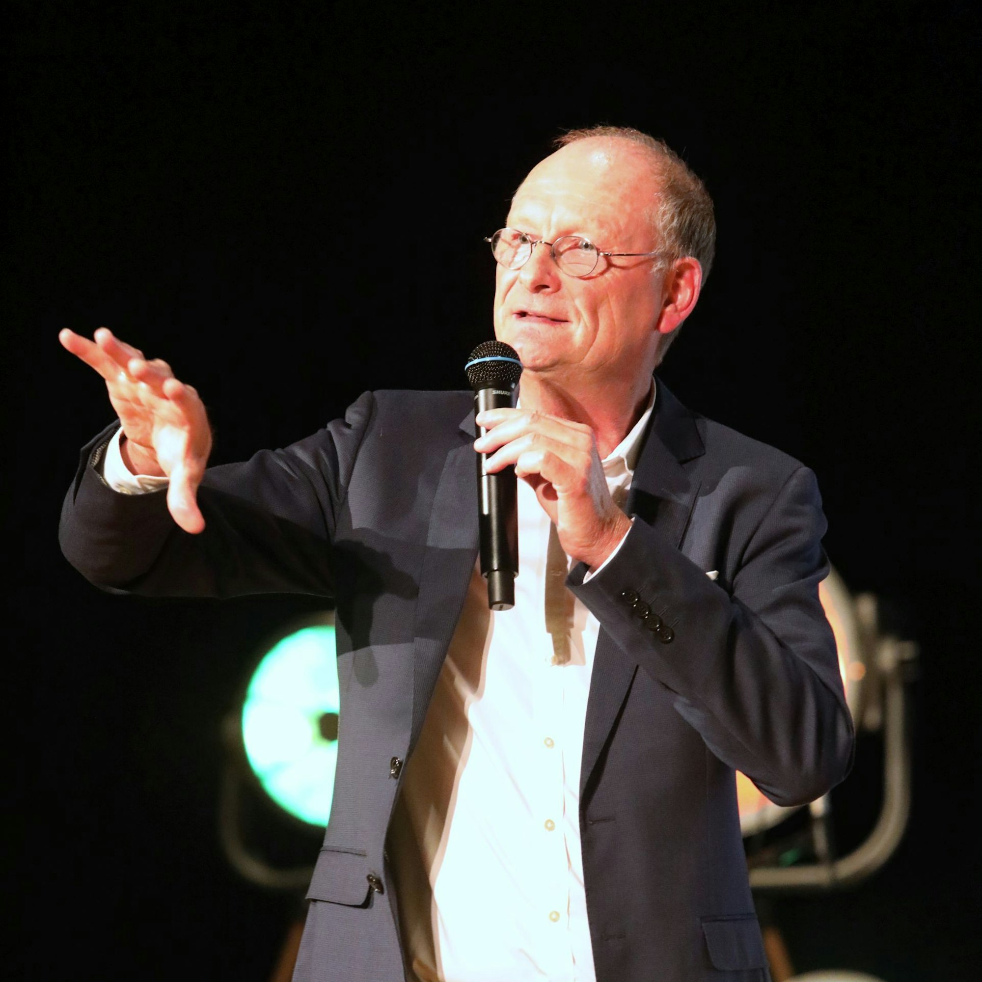 Ein Mann mit einem Mikrofon in der Hand.