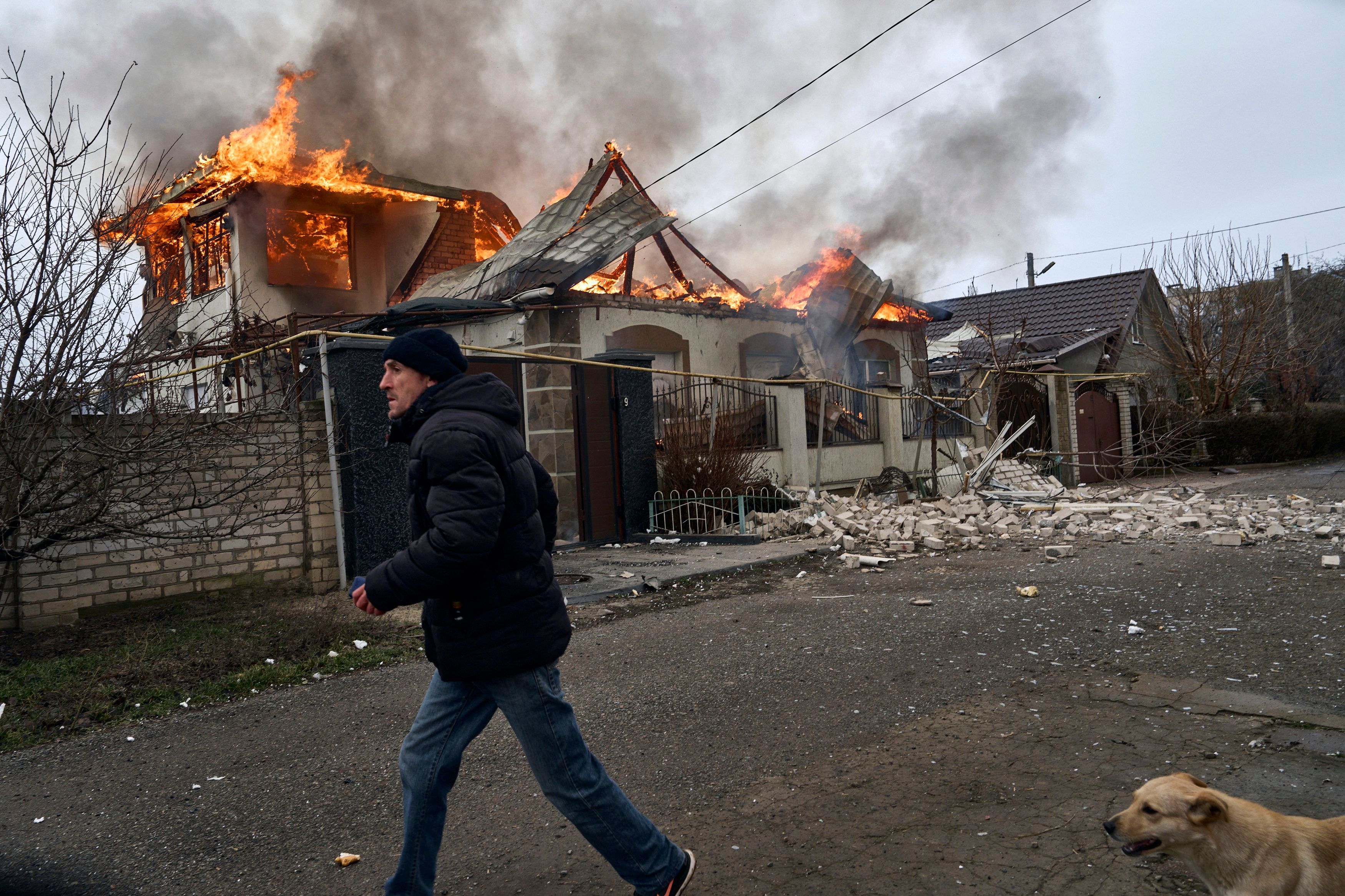 Ein Anwohner läuft an einem brennenden Haus in Cherson vorbei, das nach ukrainischen Angaben bei russischem Beschuss getroffen wurde. (Archivbild)