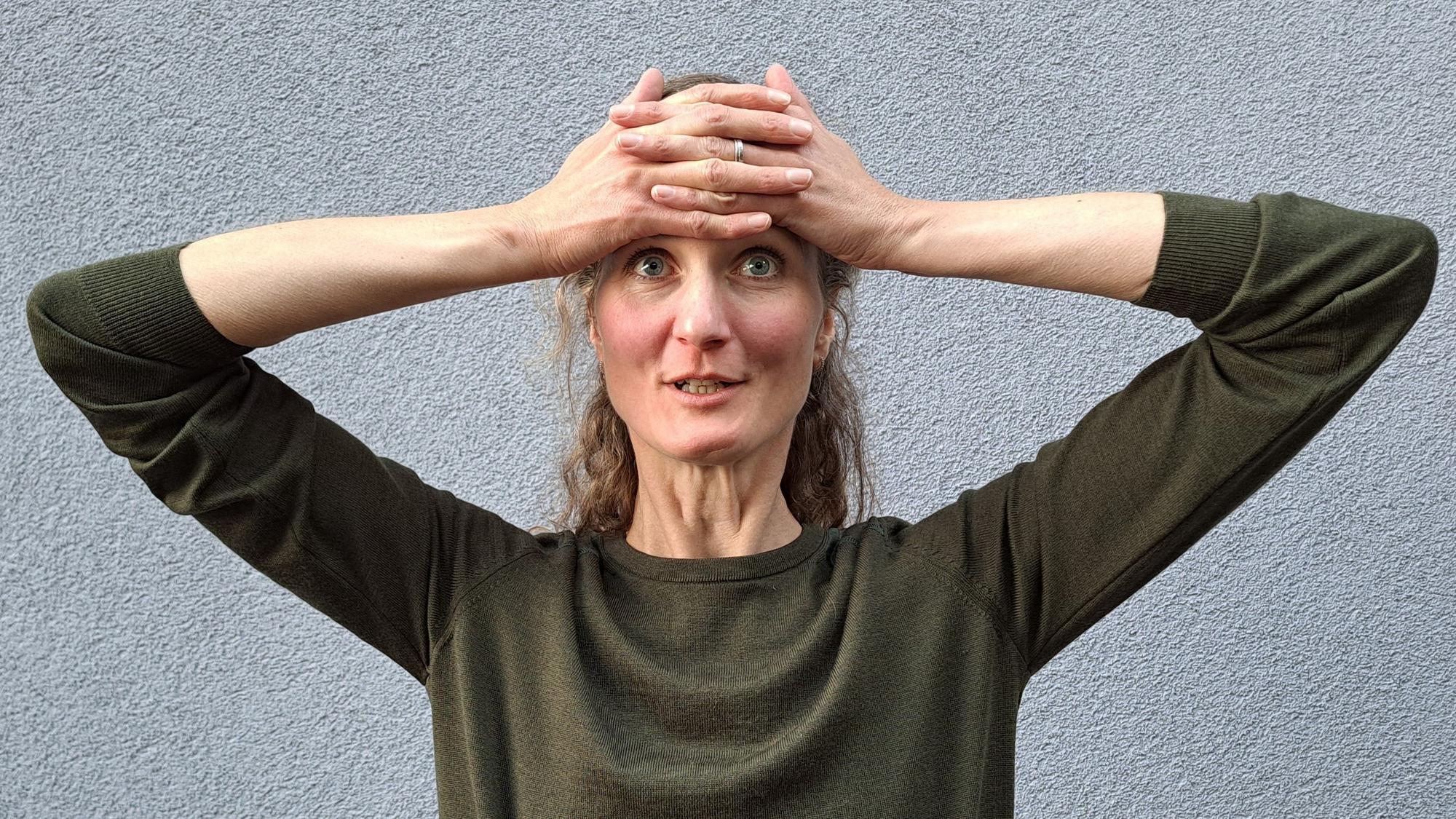 Mit beiden Händen auf der Stirn glättet Laura Hegemann Stirnfalten.