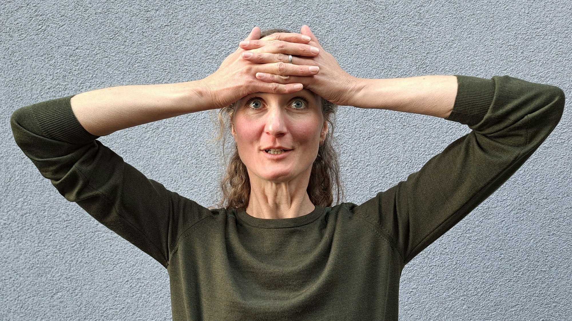 Mit beiden Händen auf der Stirn glättet Laura Hegemann Stirnfalten.