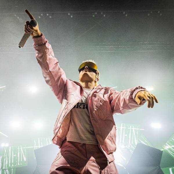 Ski Aggu steht mit pinker Jacke und Skibrille auf der Bühne.