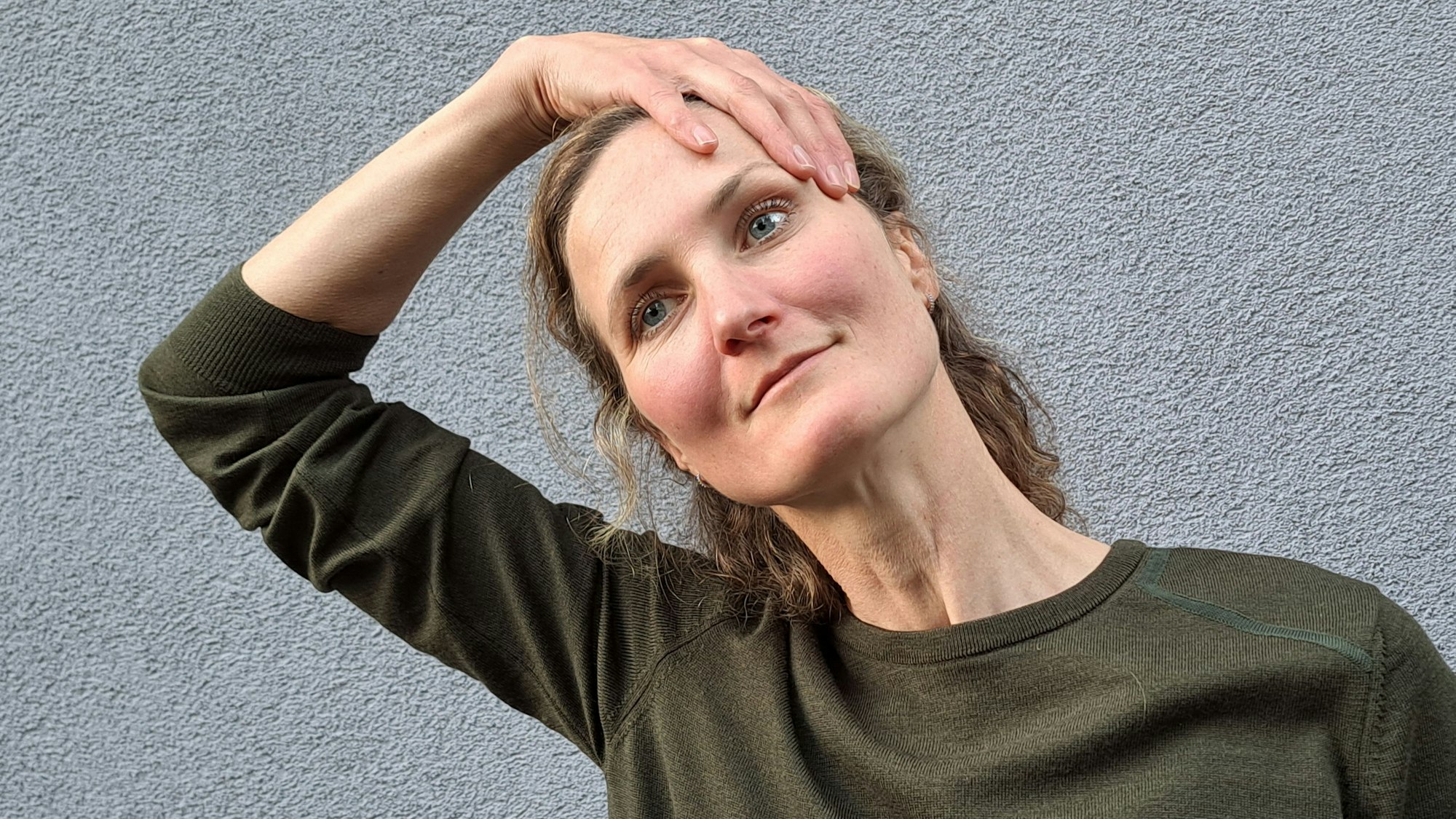 Mit einer Hand zieht Laura Hegemann ihren Kopf zu Seite.