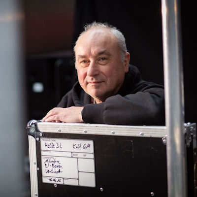 Der Porträtierte lehnt auf einer Bühnenkiste.