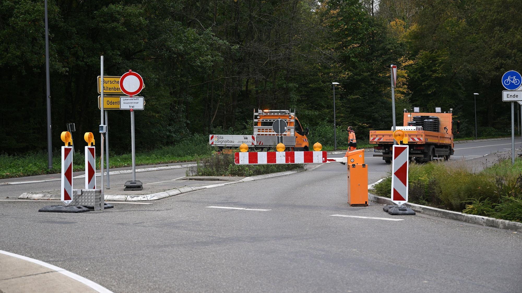 Ein Kreisverkehr, darauf Baufahrzeuge und eine Schranke.