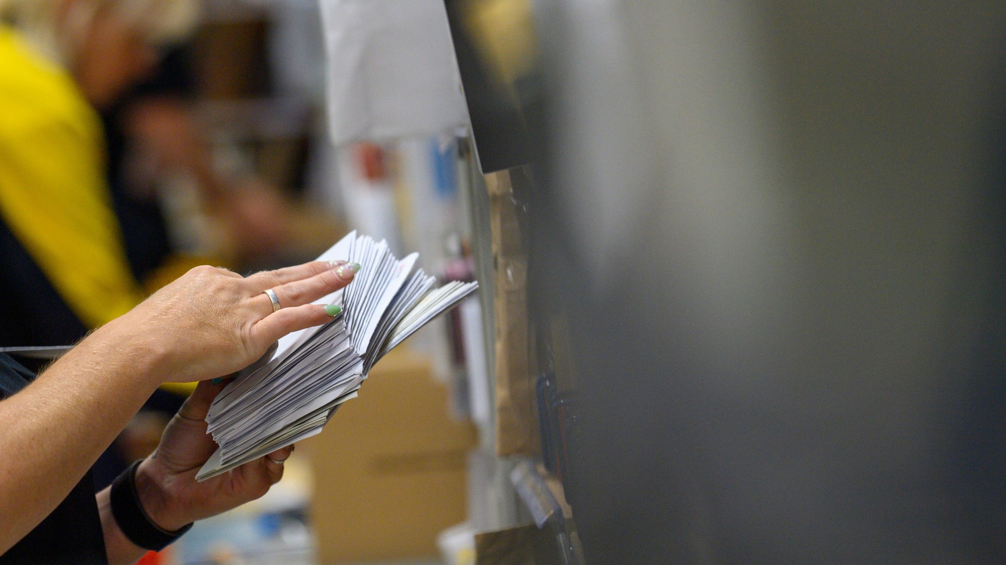 Mitarbeiter der Deutschen Post sortieren Briefe.