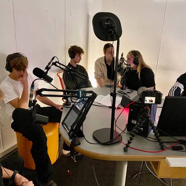 Jugendliche sitzen in einem Aufnahmestudio.