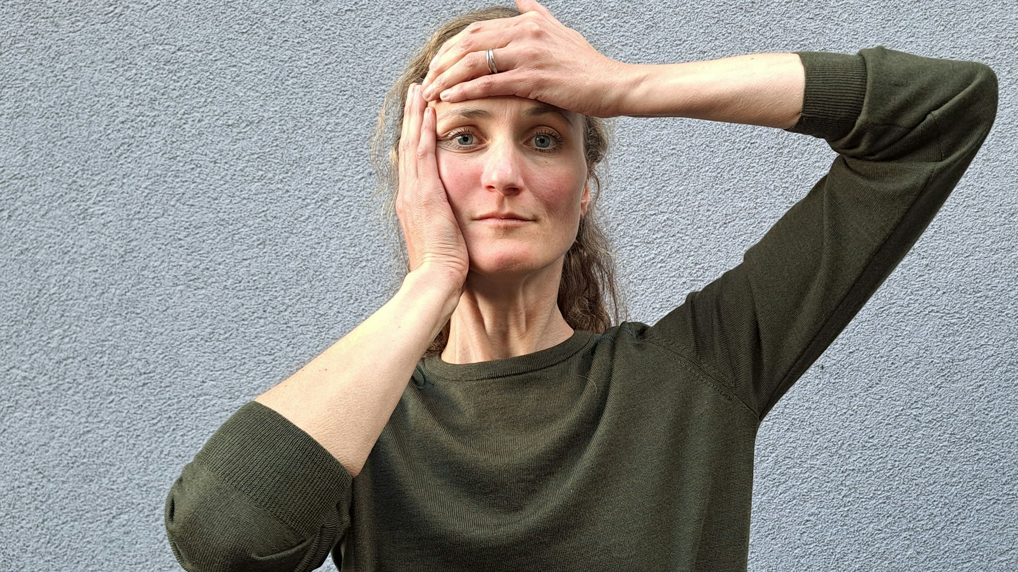 Laura Hegemann hat eine Hand auf der Stirn, die andere an der Wange.