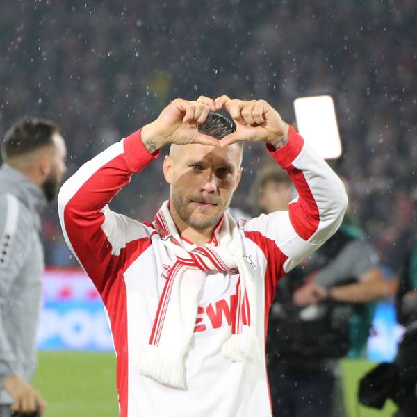 Der Fußballspieler Lukas Podolski steht auf dem Spielfeld und formt mit seinen Fingern ein Herz.