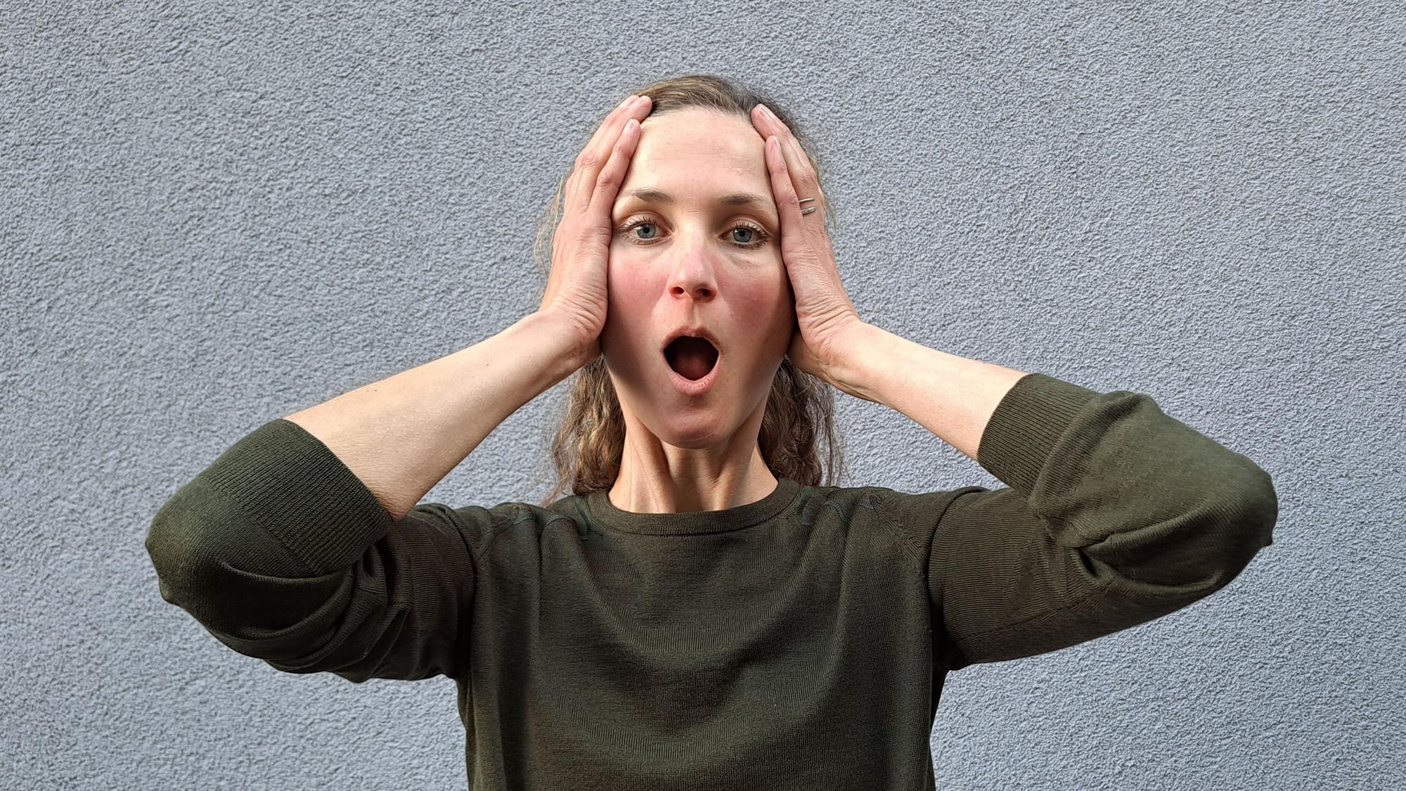 Laura Hegemann zeigt mit weit geöffnetem Mund die Face-Yoga-Übung „Big O“.