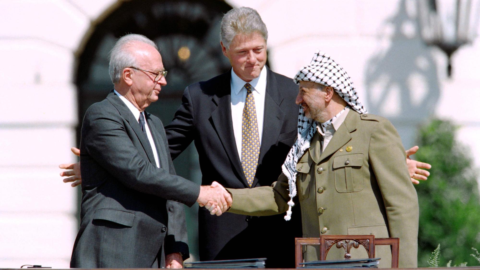 1993 schütteln sich der US-Präsident Bill Clinton, der PLO-Führer Yasser Arafat und der israelische Premierminister Yitzhak Rabin die Hand.
