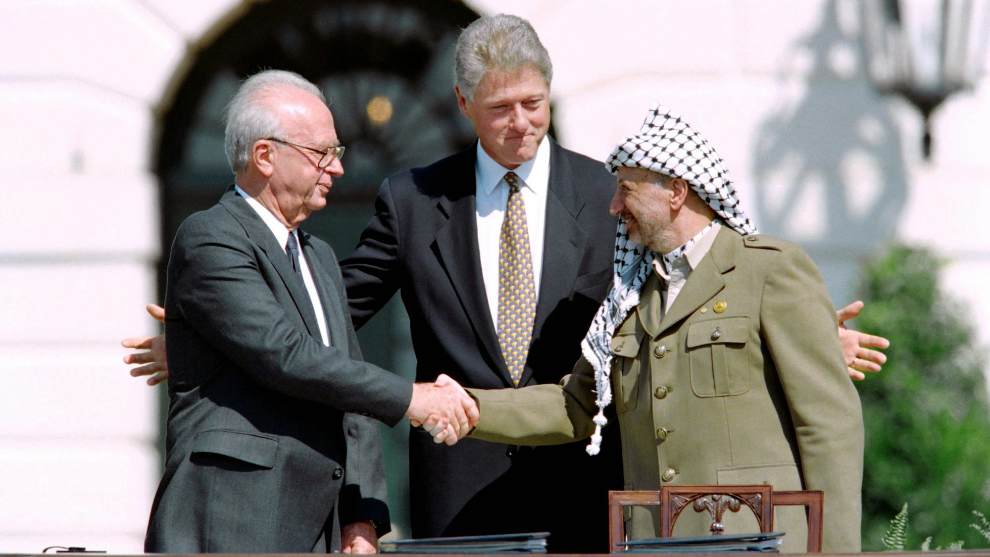 1993 schütteln sich der US-Präsident Bill Clinton, der PLO-Führer Yasser Arafat und der israelische Premierminister Yitzhak Rabin die Hand.