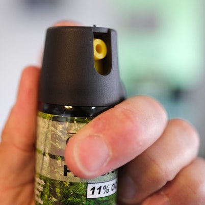 Eine Hand hält eine Kartusche mit Pfefferspray.