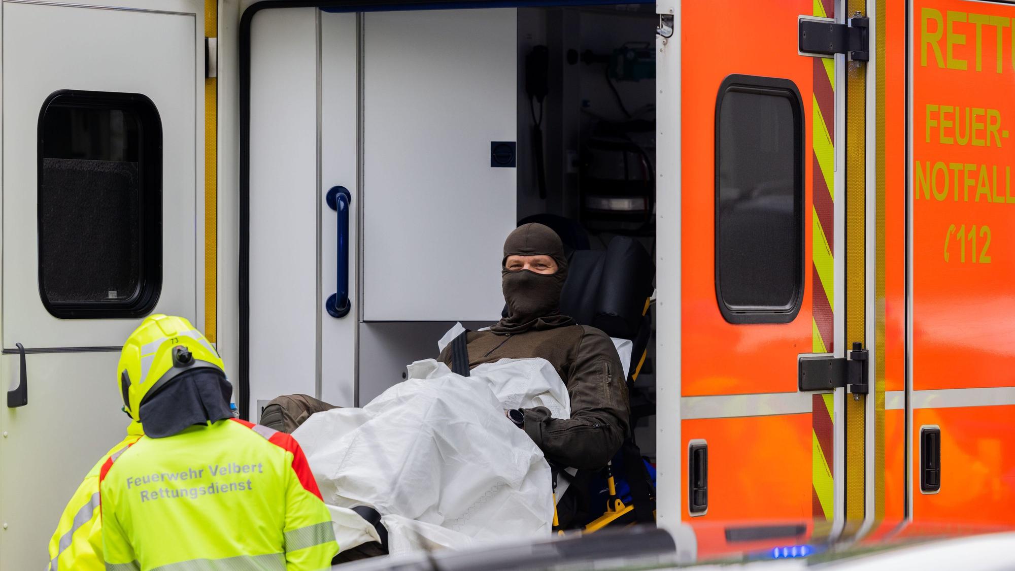 Ein verletzter Polizeibeamter wird in einen Krankenwagen gebracht.