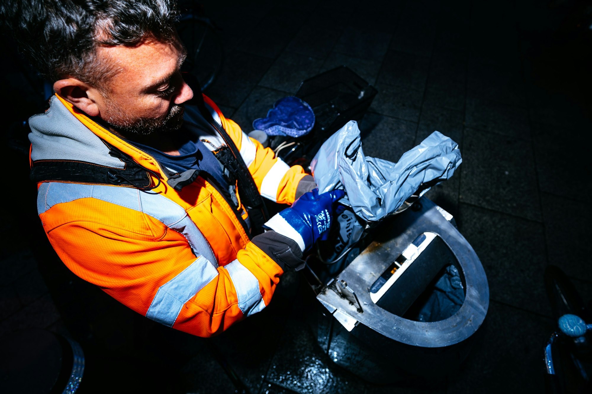 Ein Mitarbeiter der AWB wechselt die Mülltüte aus einem Mülleimer.