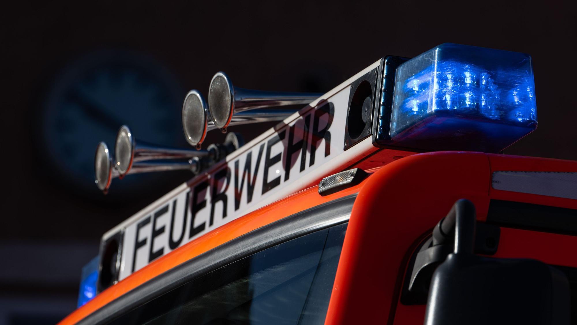Ein Einsatzfahrzeug der Feuerwehr mit eingeschaltetem Blaulicht.