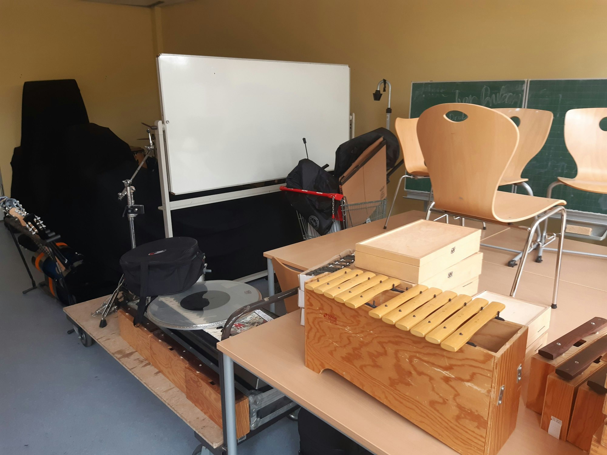 Das Bild zeigt einen Klassenraum, der mit Musikinstrumenten vollgestellt ist.