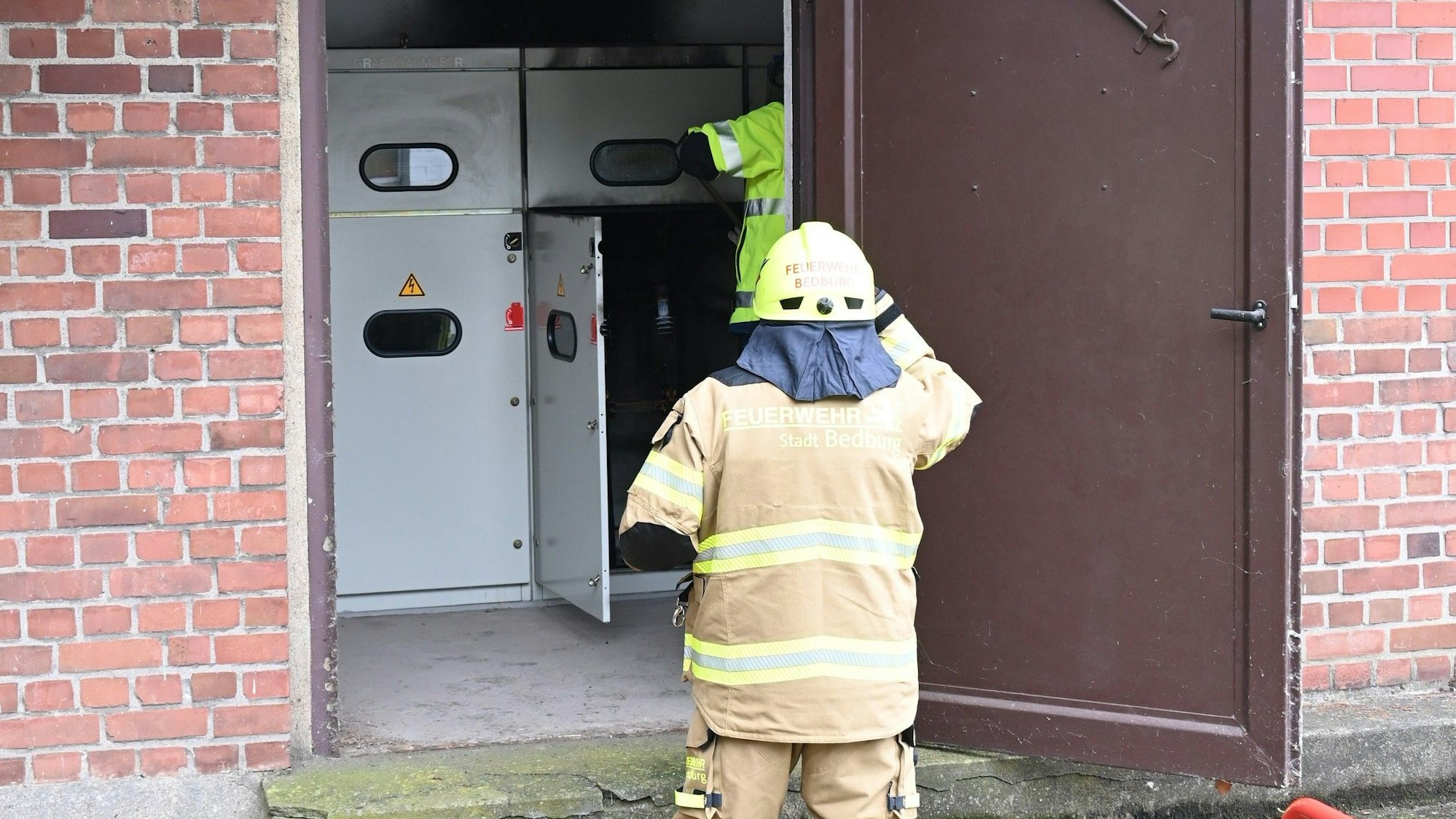 Das Bild zeigt einen Feuerwehrmann vor einem Schaltkasten.