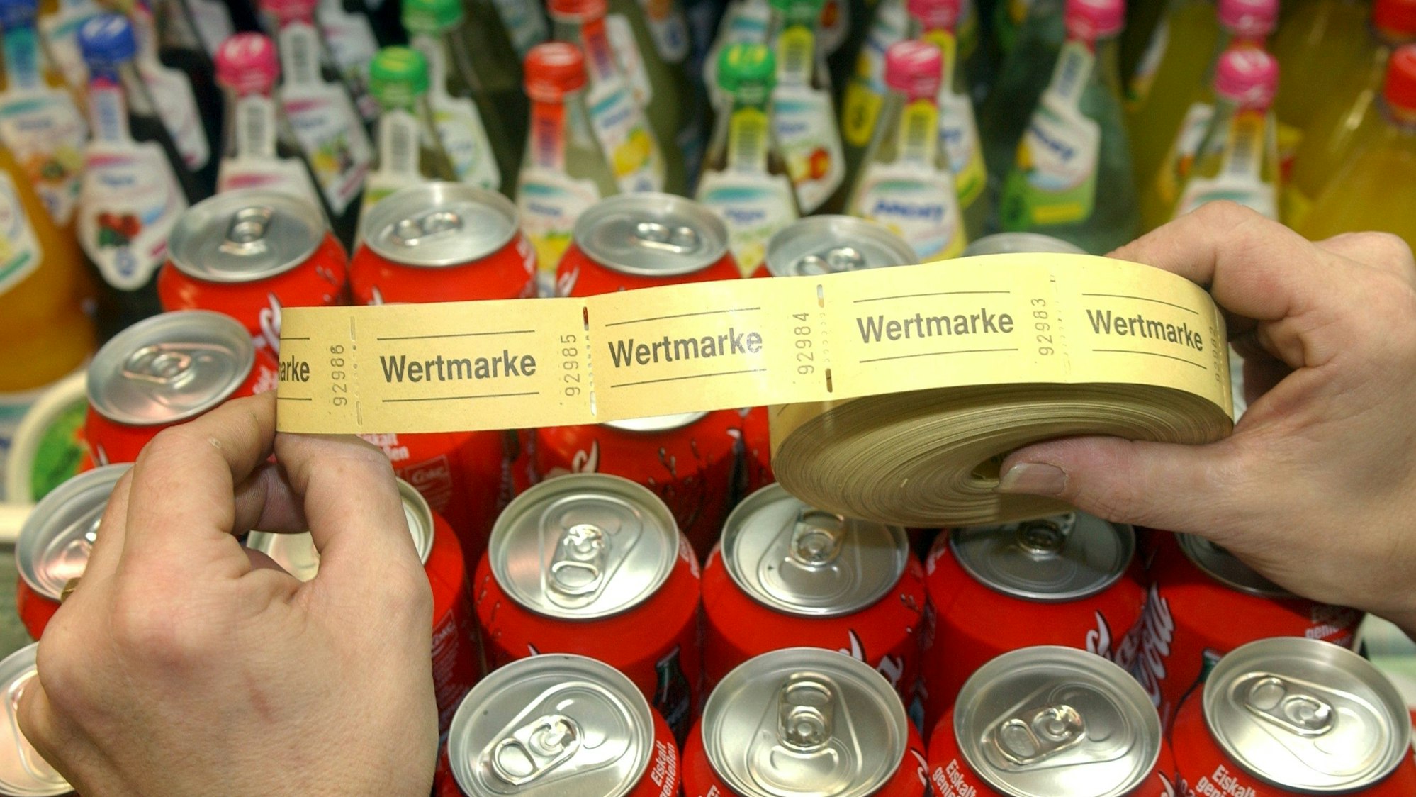 Eine Rolle mit Wertmarken aus Papier und Getränke in Dosen und Flaschen