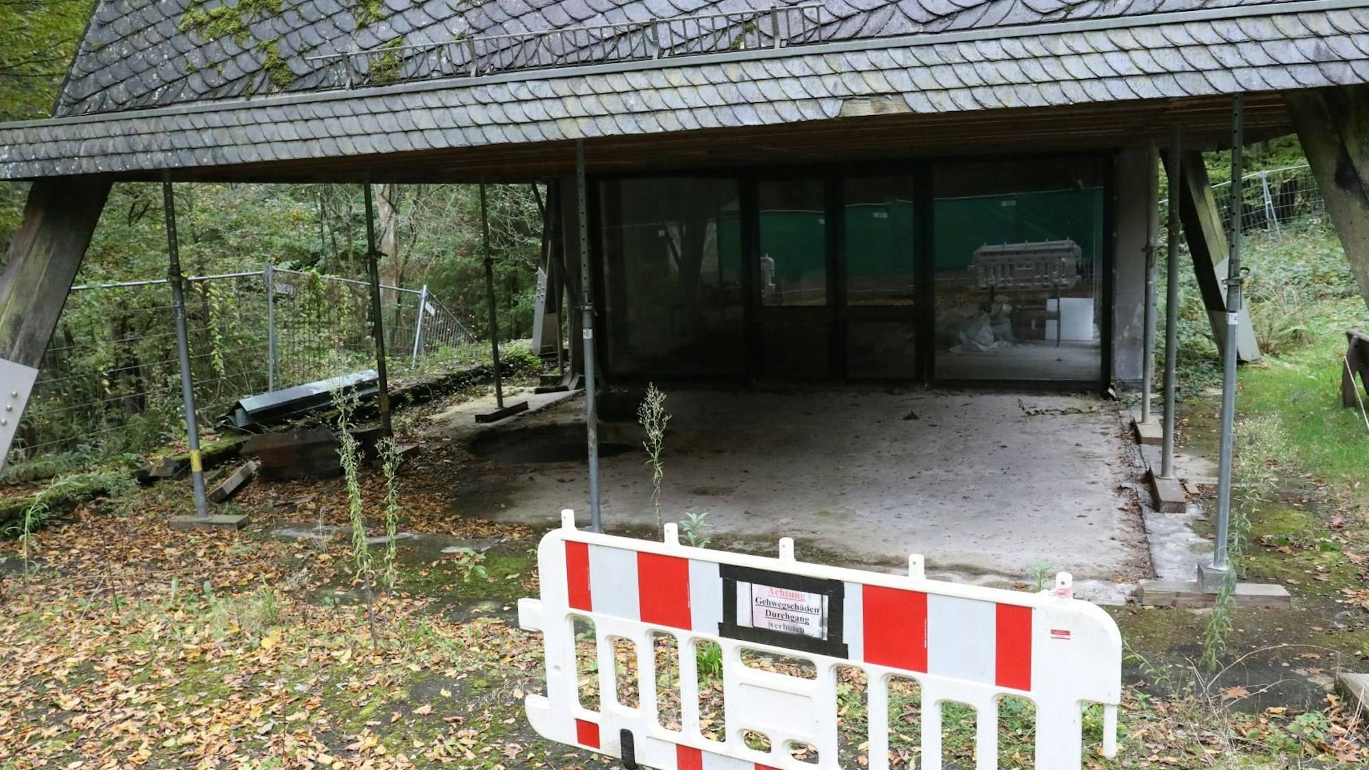 Stahlstreben stützen das Dach der Kapelle, im Vordergrund steht ein rot-weiße Sperrbake,