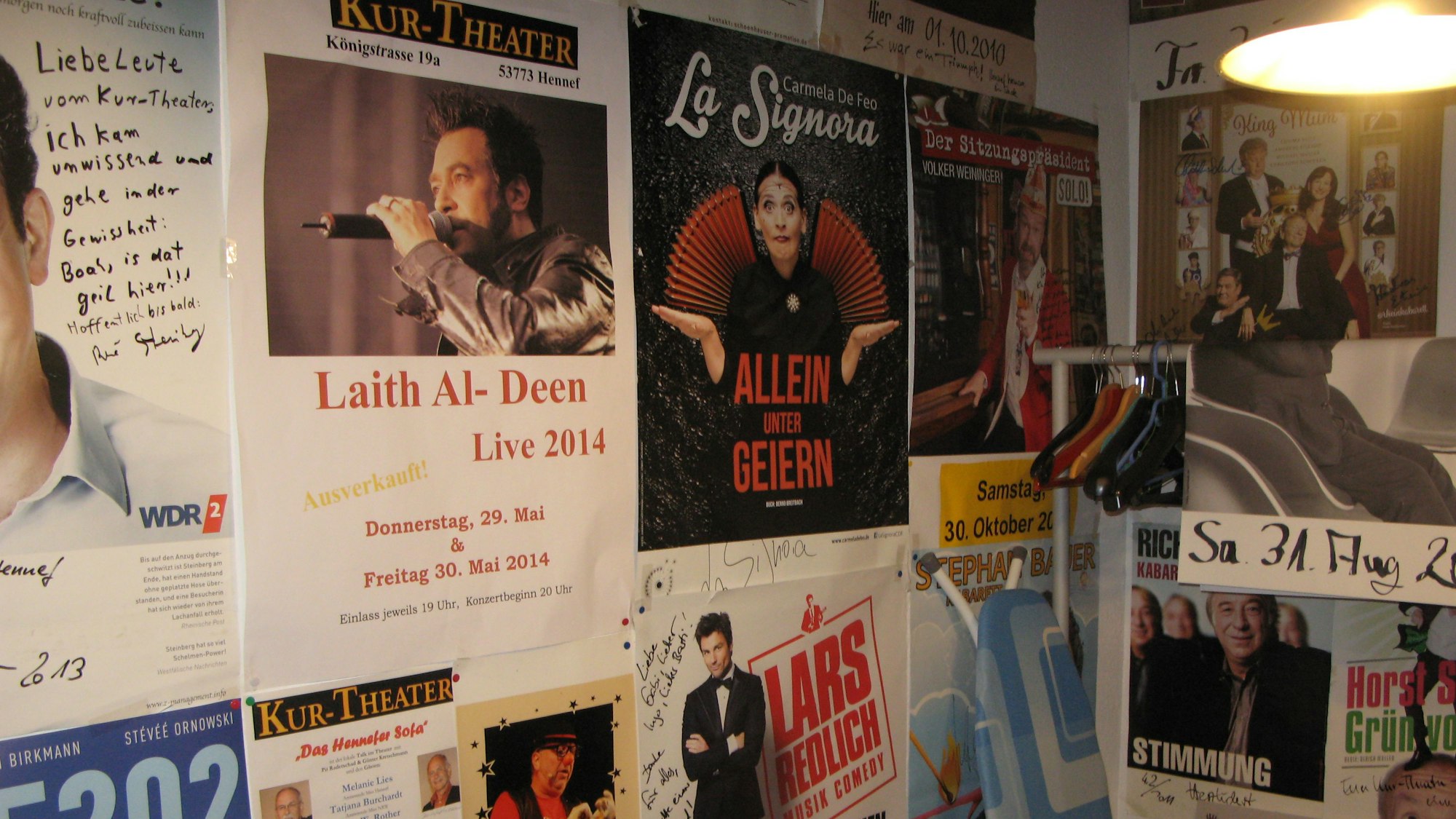 Etliche Veranstaltungsplakate hängen an den Wänden in einem Raum.