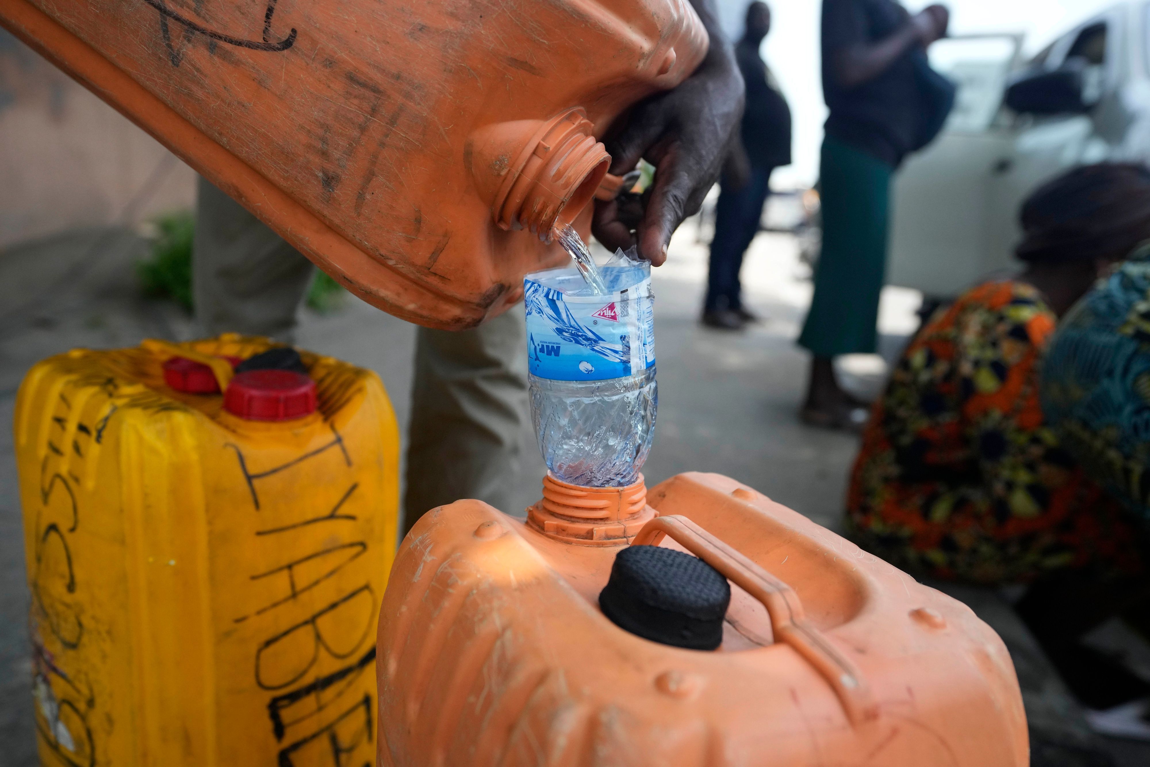ARCHIV - 30.04.2024, Nigeria, Lagos: ILLUSTRATION - Ein Mann verkauft Kraftstoff in der Nähe einer Tankstelle in Nigeria.  (zu dpa: «Mindestens 94 Tote nach Explosion von Tanklaster in Nigeria») Foto: Sunday Alamba/AP/dpa +++ dpa-Bildfunk +++