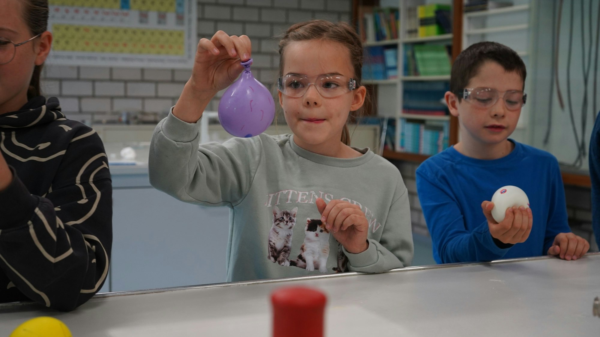 Das Foto zeigt ein junges Mädchen, das einen Ballon hochhält.
