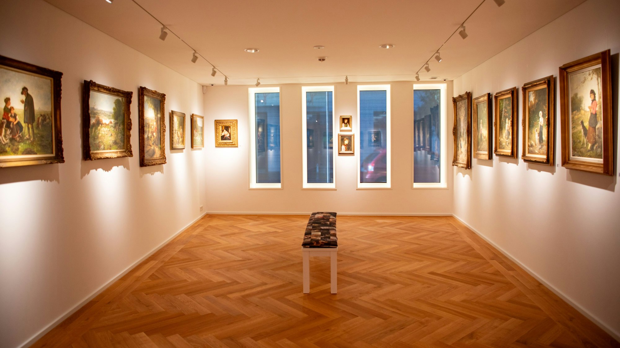 Eine Bank steht in einem der Ausstellungsräume des neuen Hubert-Salentin-Museums in Zülpich. An den Wänden hängen Gemälde.