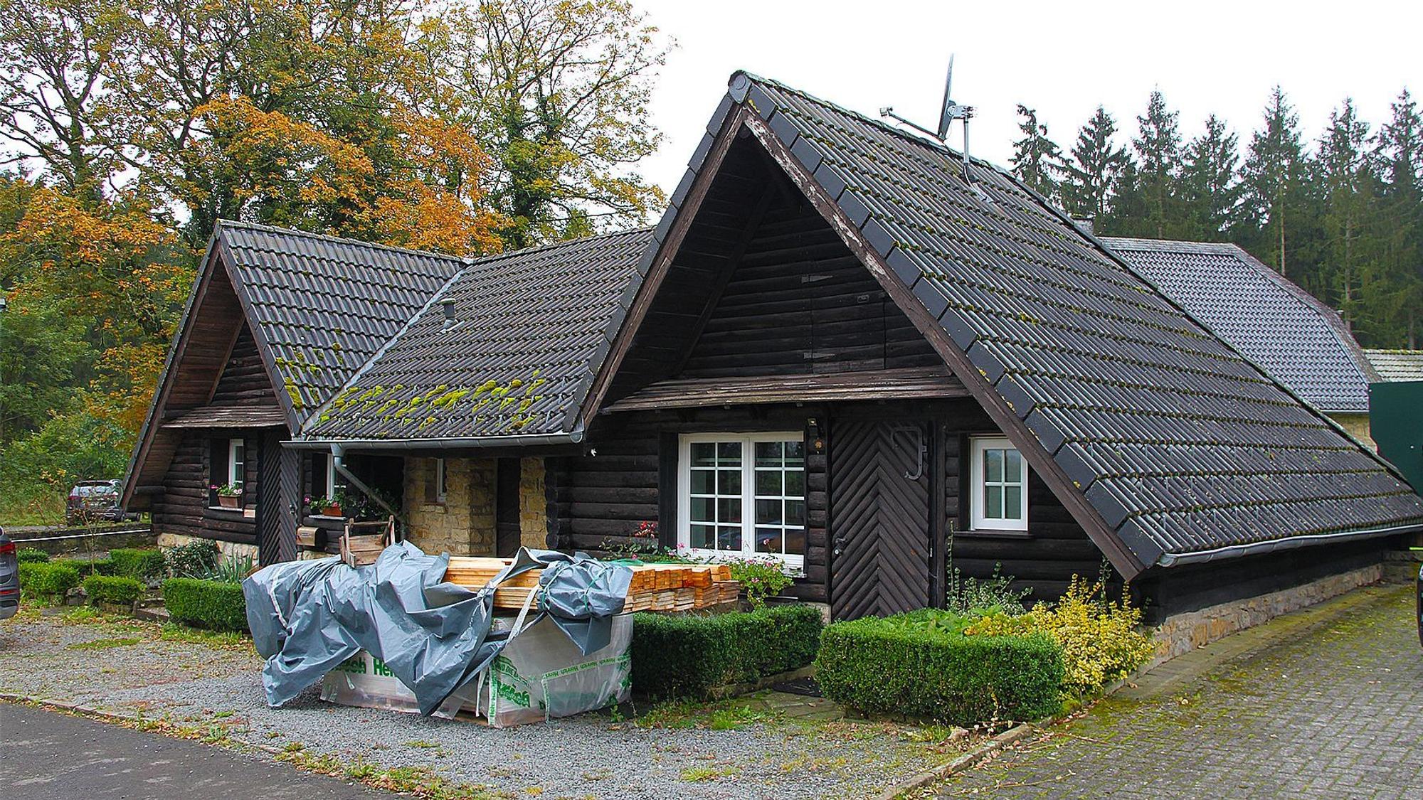 In zwei kleinen,aus dunklem Holz gebauten Spitzdachhäuschen wird ein Café eingerichtet.