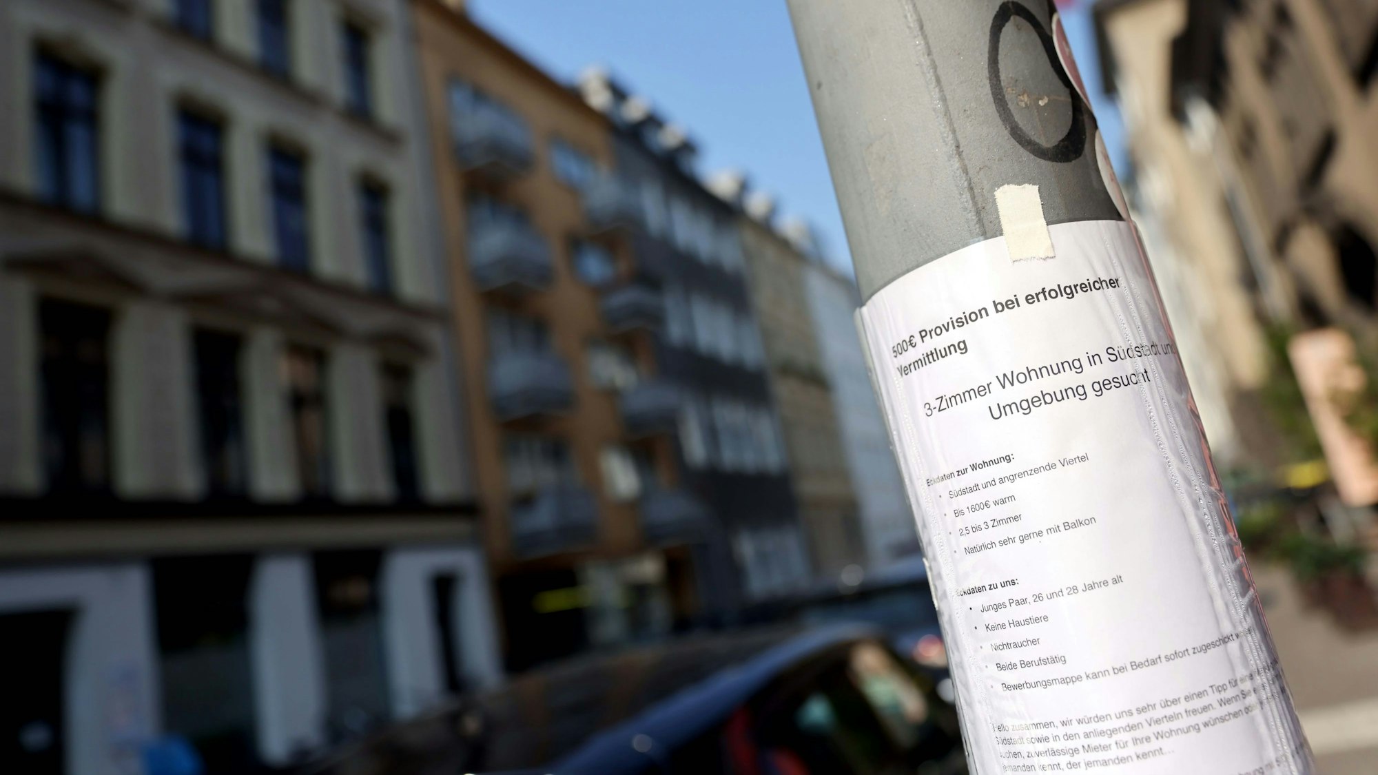 Zu sehen ist ein Zettel mit einem Wohnungsgesuch an einem Laternenpfahl.