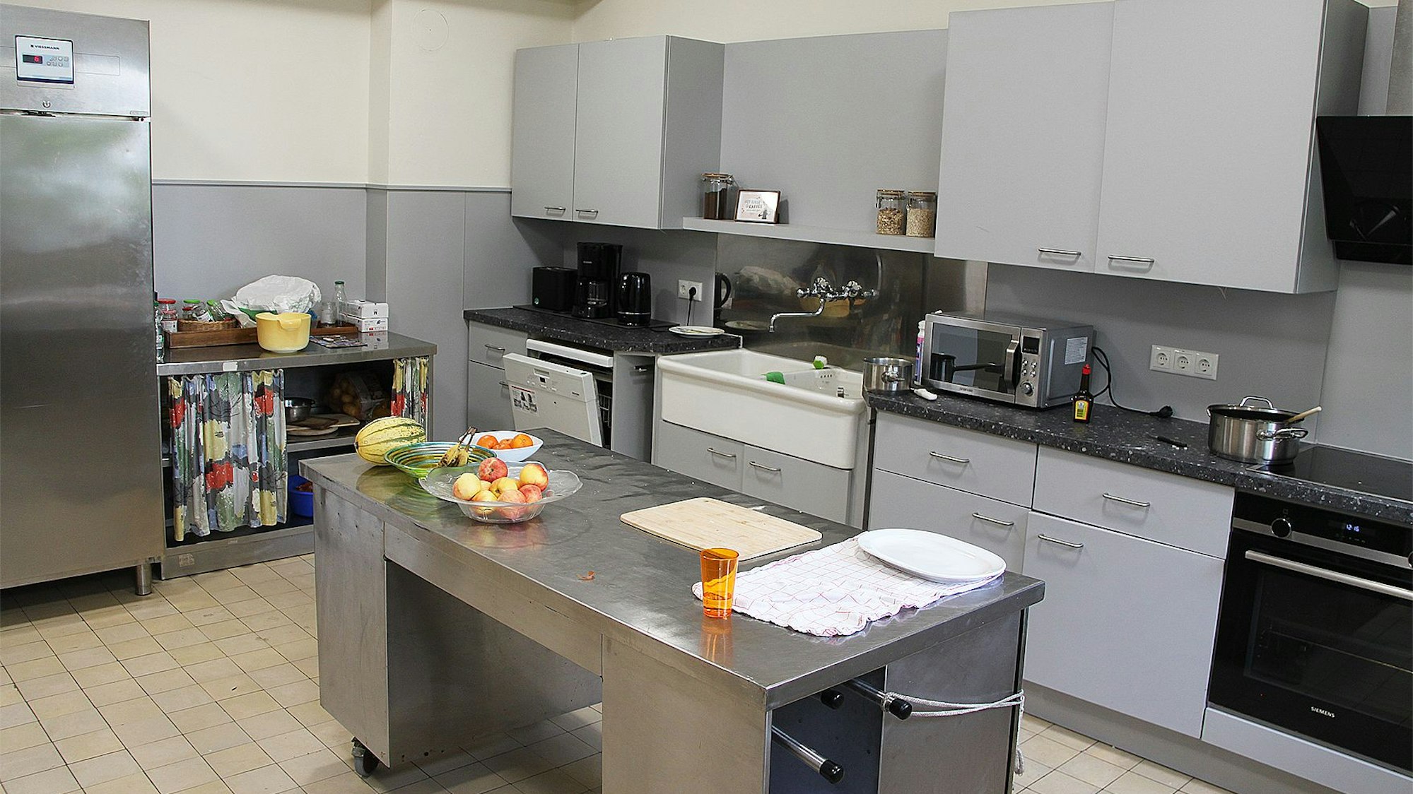 Eine Gemeinschaftsküche mit grauen Fronten ist in dem ehemaligen Kloster eingerichtet.