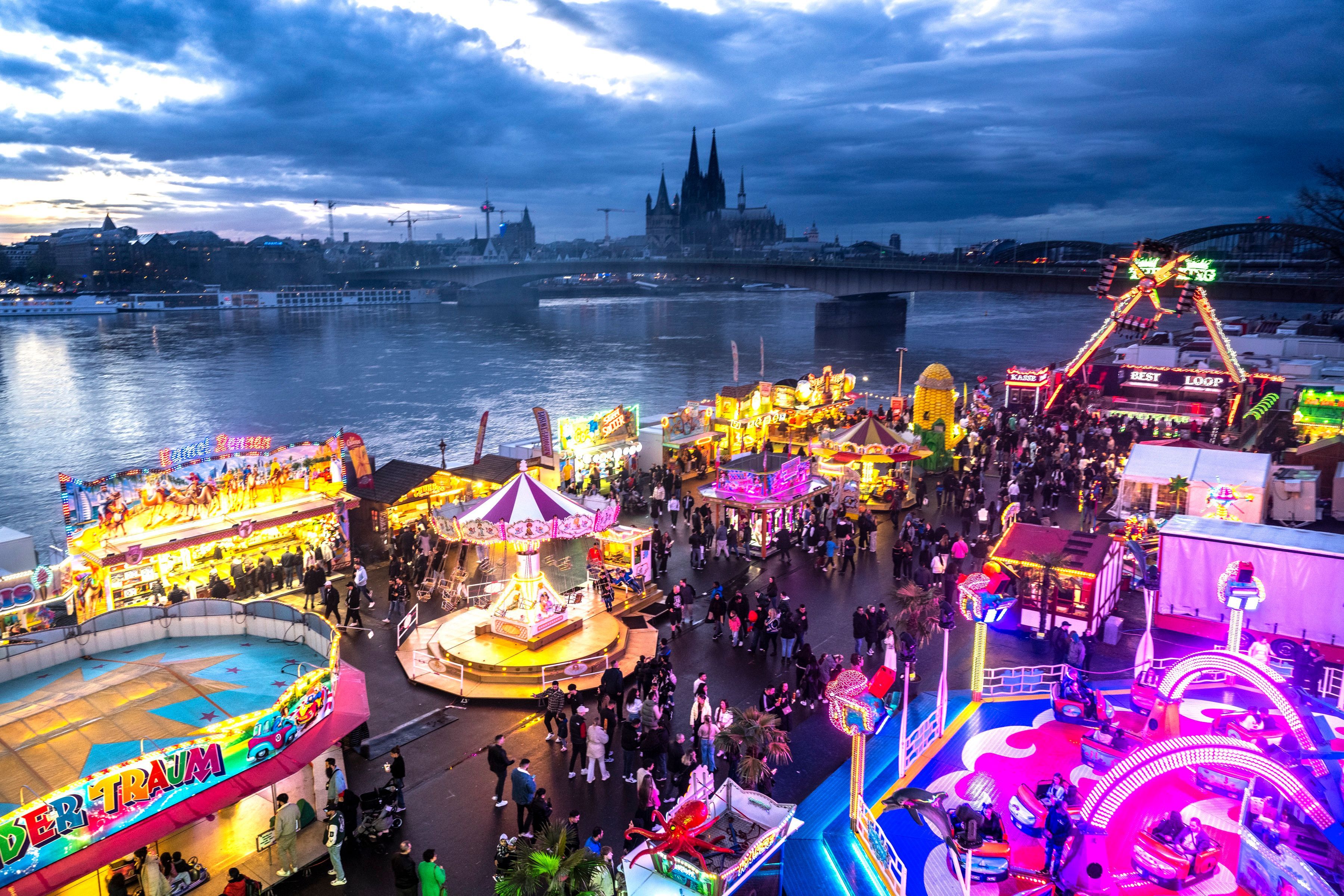 31.03.2024, Köln: Die Deutzer Kirmes leuchtet in der Abenddämmerung. Im Vorfeld hatte es auch Streitigkeiten um die Stromversorgung gegeben. Foto: Uwe Weiser