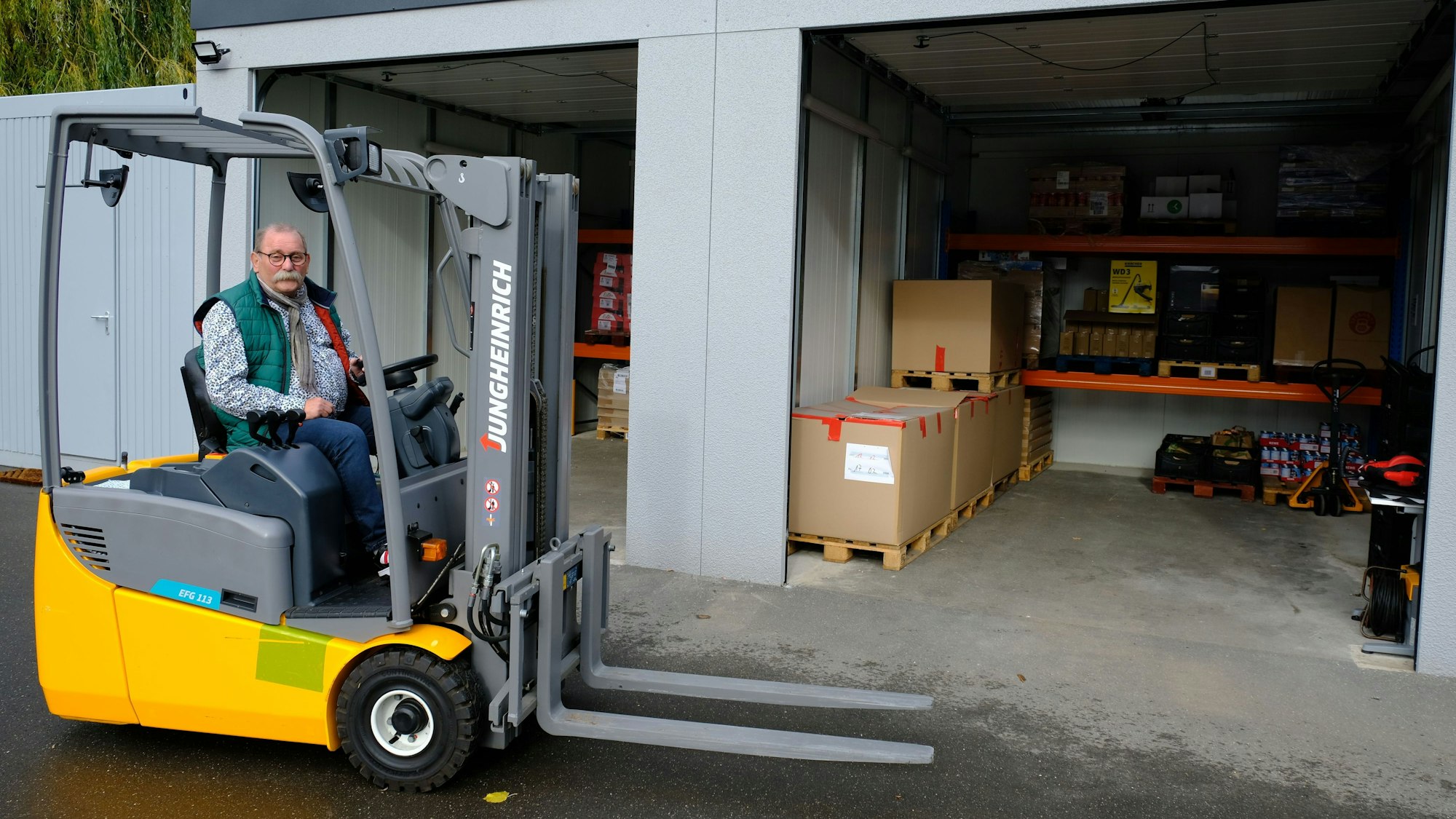 Tafel-Vorsitzender Wolfgang Weilerswist mit einem Gabelstapler vor dem Lebensmittellager in Mechernich.