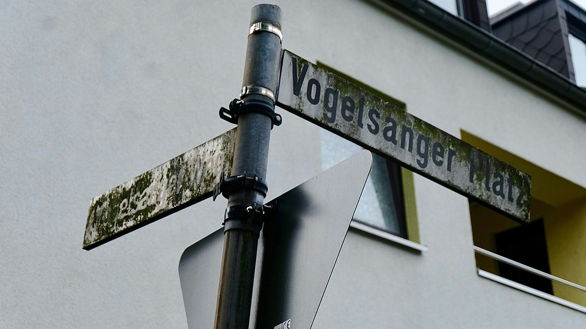 An der Ecke Vogelsanger Weg/Vogelsanger Platz sind die Straßenschilder von einer grünen Dreckschickt überzogen.