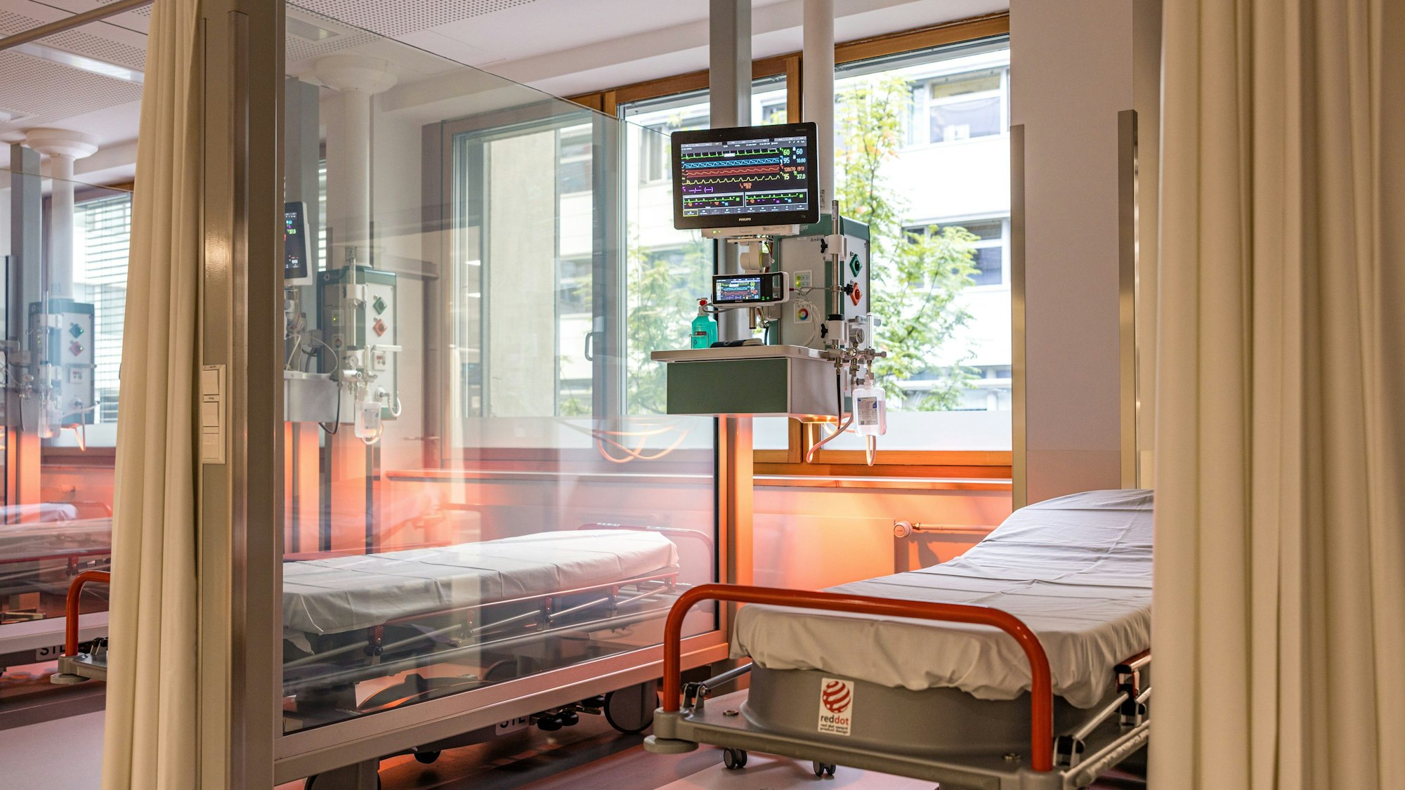 Durch Scheiben voneinander getrennte Betten stehen in der Notaufnahme