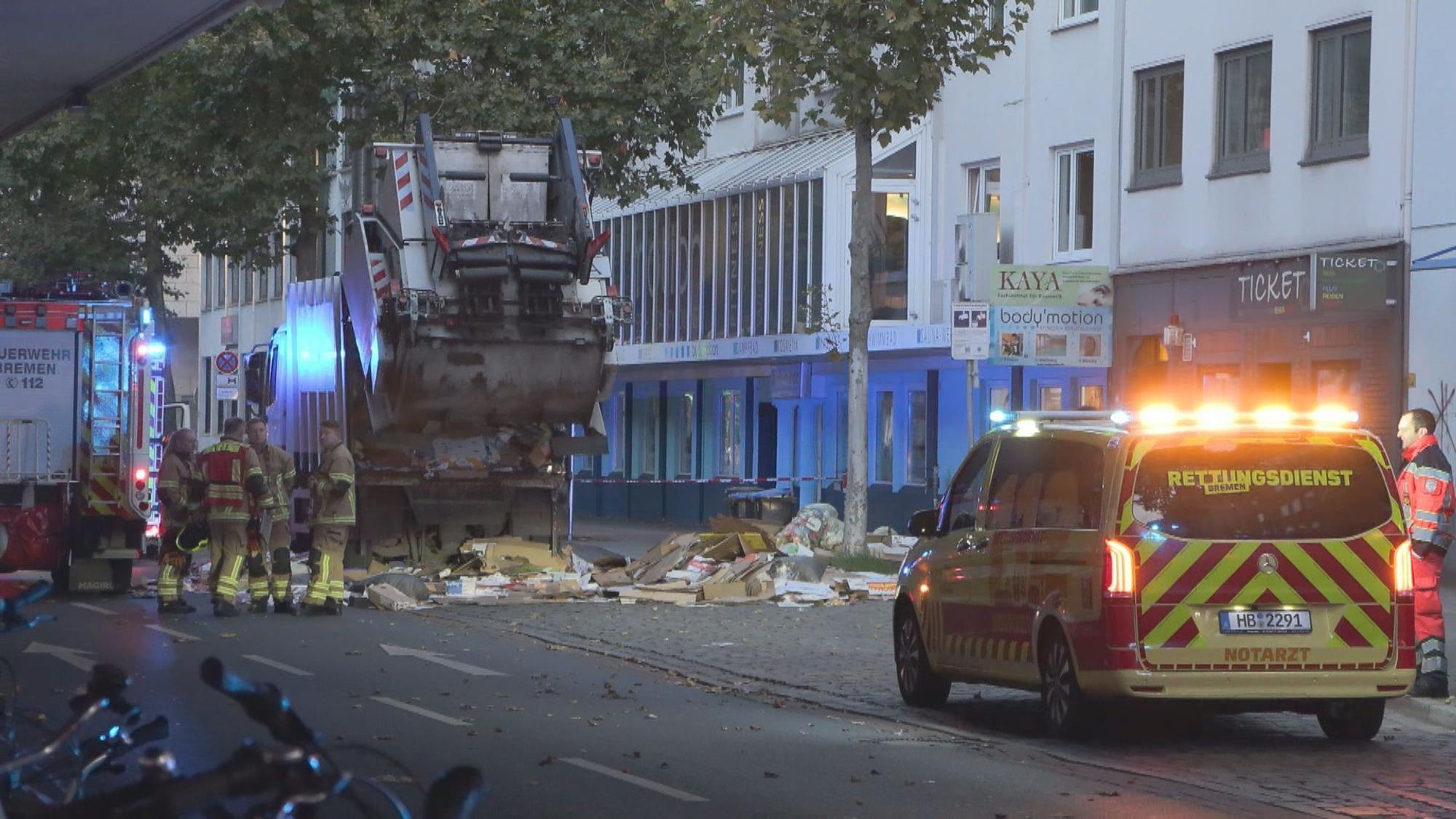 Mehrere Rettungsfahrzeuge und Einsatzkräfte treffen an dem Müllwagen der Stadtreinigung an, in dem der tote Mann aufgefunden wurde.