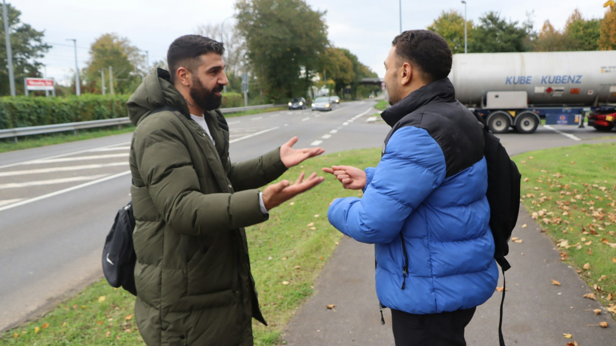 Zwei Männer sprechen, einander zugewandt, miteinander.