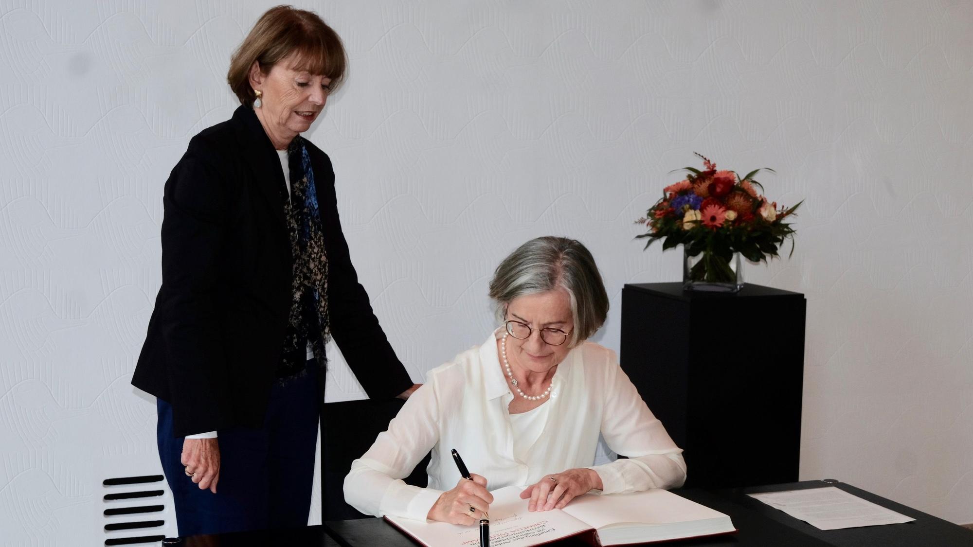 Cornela Weitekamp trägt sich in das Gästebuch der Stadt Köln ein, an der Seite von Henriette Reker.