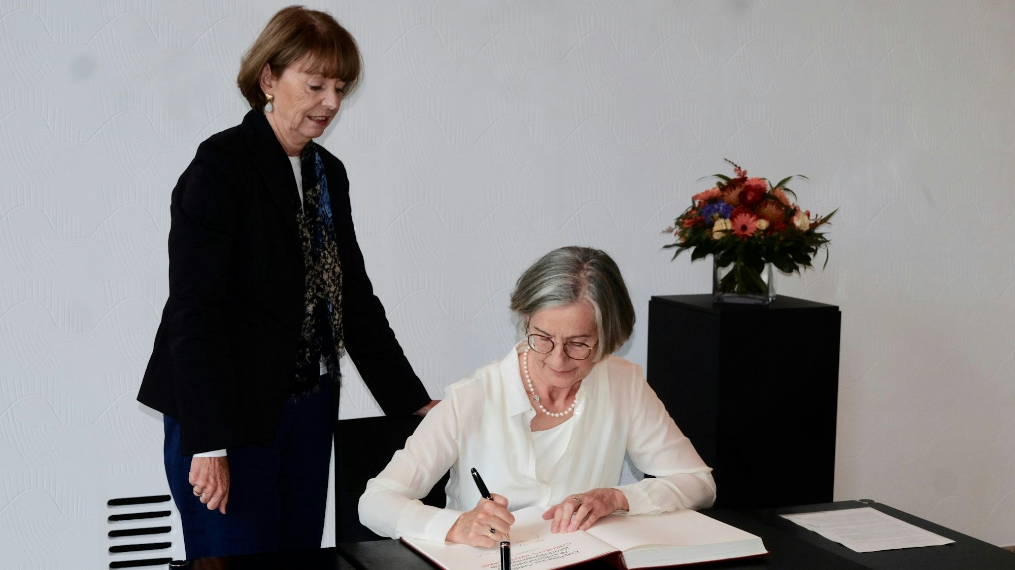 Cornela Weitekamp trägt sich in das Gästebuch der Stadt Köln ein, an der Seite von Henriette Reker.