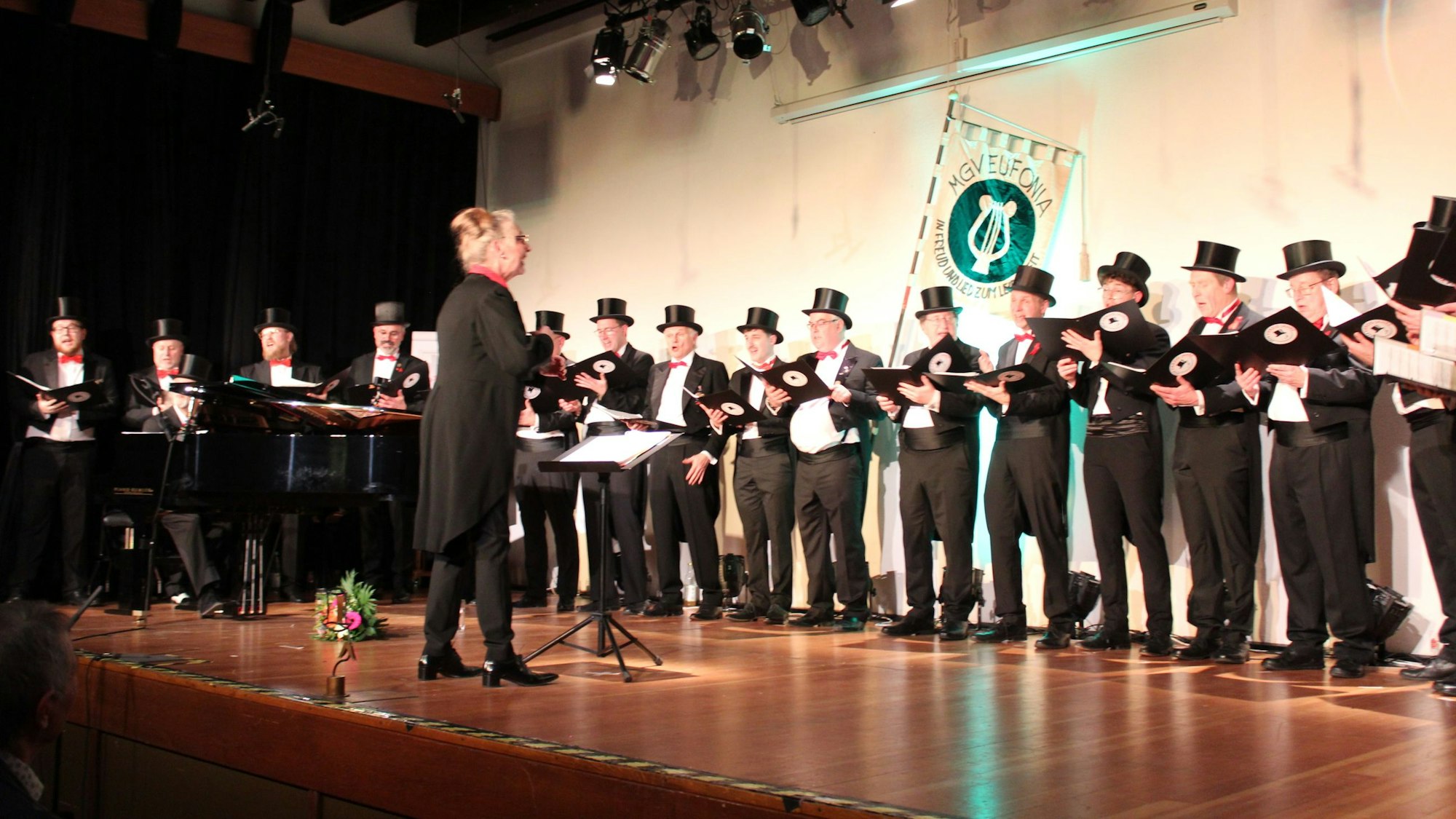 Das Bild zeigt die Eufonisten mit ihrer Dirigentin auf der Bühne.