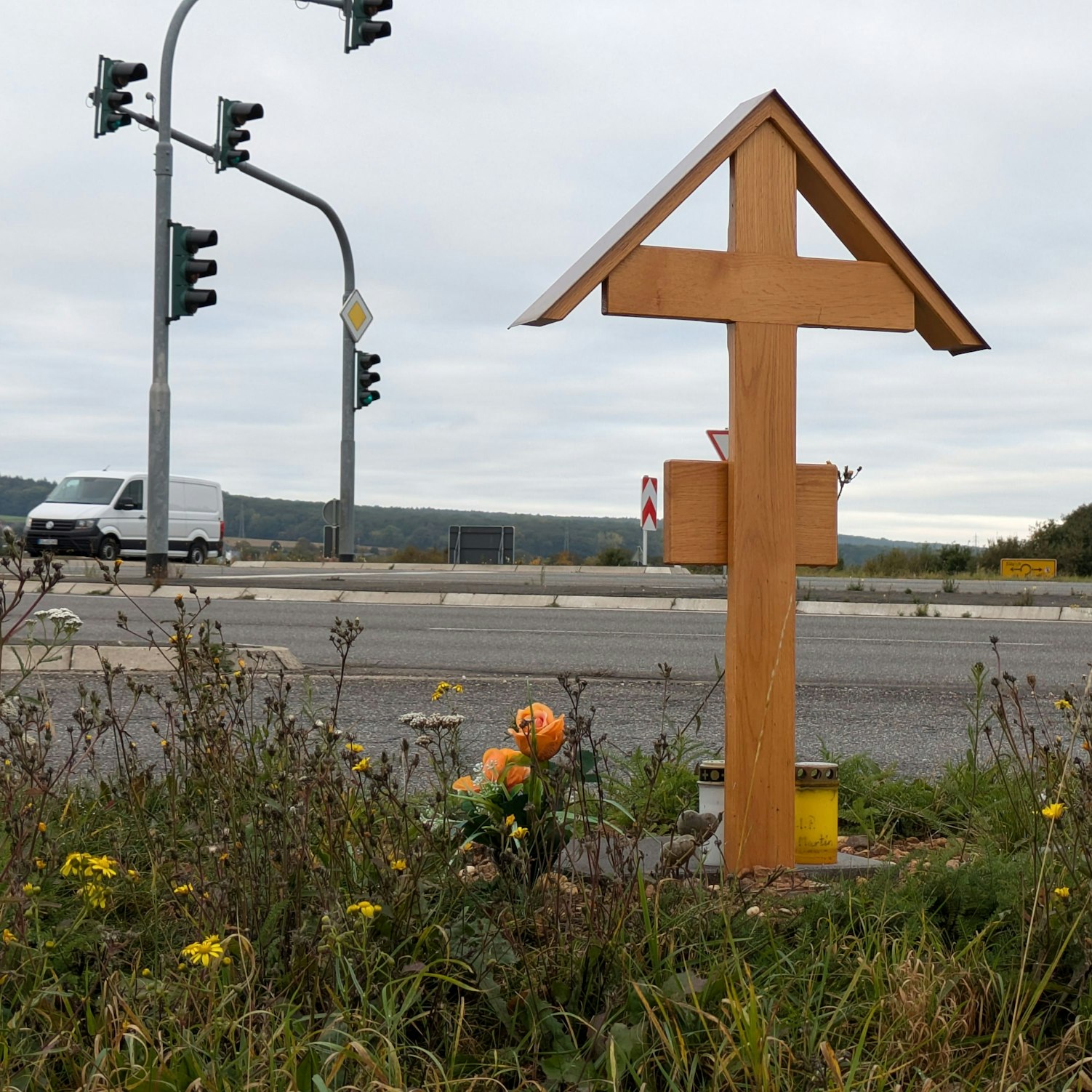 Ein Holzkreuz steht an einer Kreuzung in Euskirchen. Es erinnert an das Opfer eines tödlichen Unfalls.