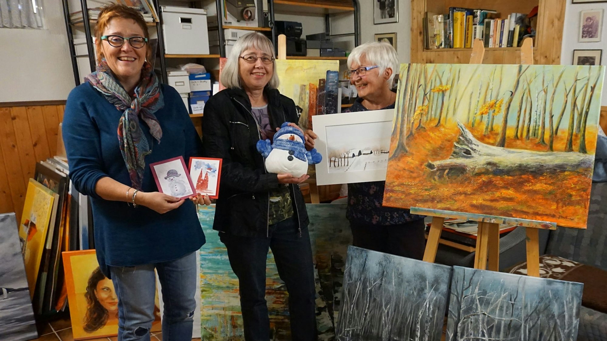 Das Foto zeigt drei Frauen, die ihre Kunst präsentieren.