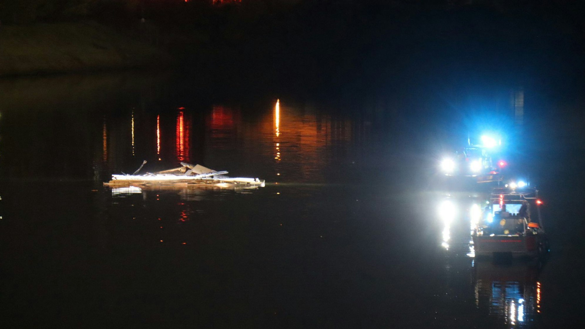 17.10.2024, Baden-Württemberg, Mannheim: Teile eines Schiffes schwimmen im Wasser im Industriehafen während Boote im Einsatz sind. Nachdem ein Schiff in mit dem Steuerhaus an einer Brücke in Mannheim hängengeblieben und das Steuerhaus abgerissen ist, ist die Brücke für den Verkehr gesperrt. Foto: Marco Priebe/dpa +++ dpa-Bildfunk +++