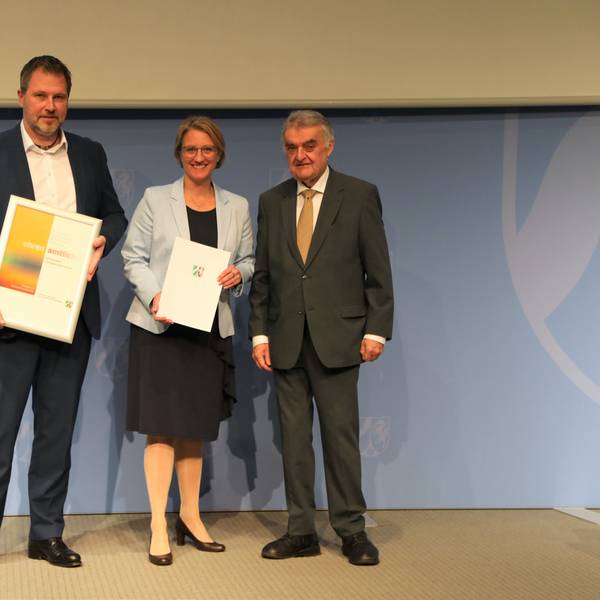 Minister Herbert Reul überreicht eine Förderplakette an die Kampf-Vertreter Markus Vollmer und Rike Svea Johnsen.