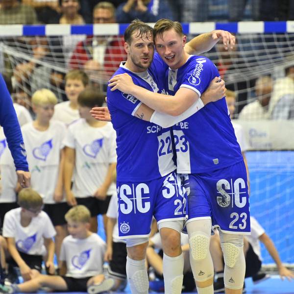 Kentin Mahe und Ole Pregler gehen umschlungen über Spielfeld.
