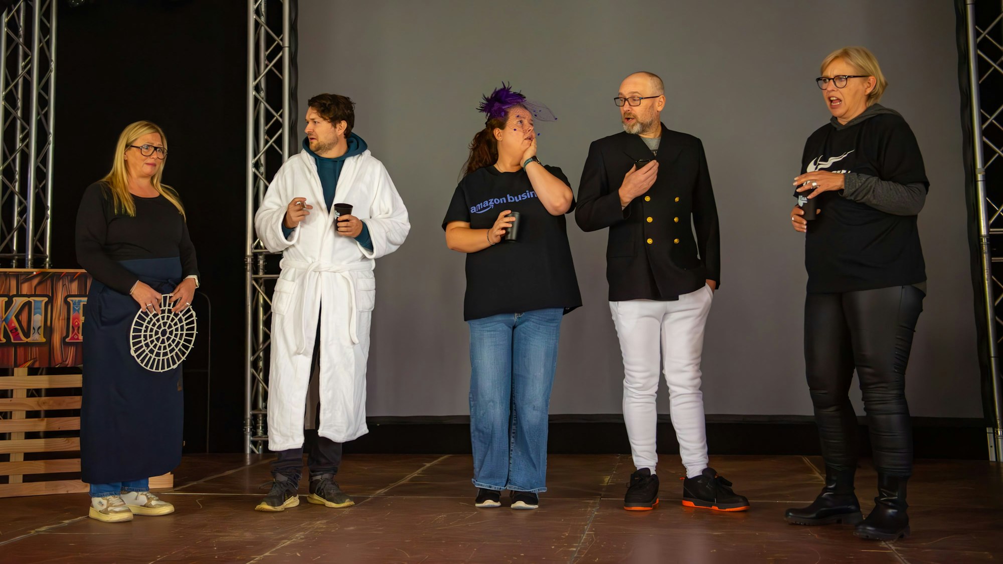 Drei Frauen und zwei Männer stehen auf einer Bühne und unterhalten sich. Einer trägt Einenen Bademantel. Birte Karsten (v.l.), Julius Esser, Eva Lebertz, Jens Bongard und Isa Oestmann proben für die Sitzungen der Liga der alternativen Karnevalisten.