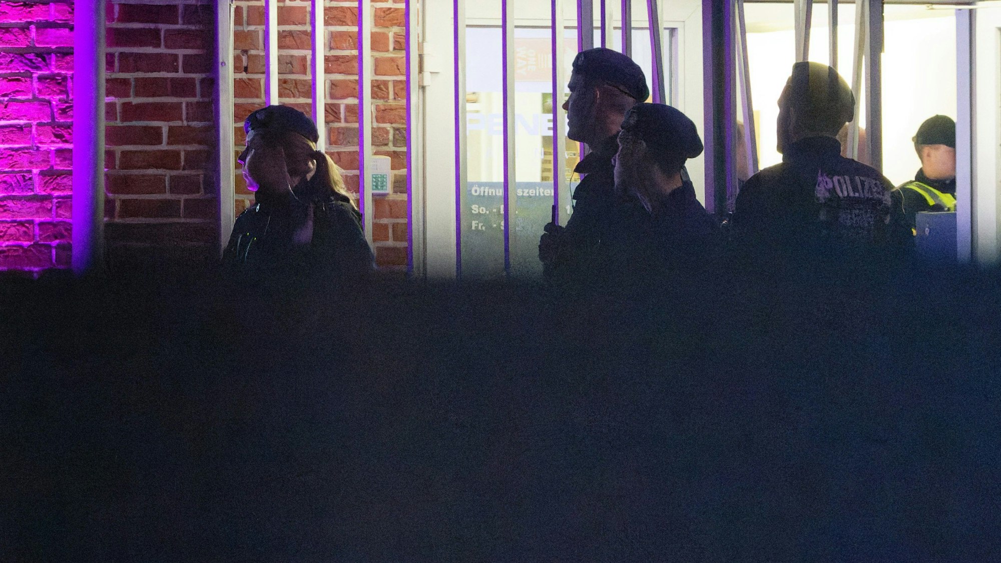 Castrop-Rauxel: Ein Polizist und Zollbeamte stehen während einer Razzia im Ruhrgebiet vor einem Saunaclub.