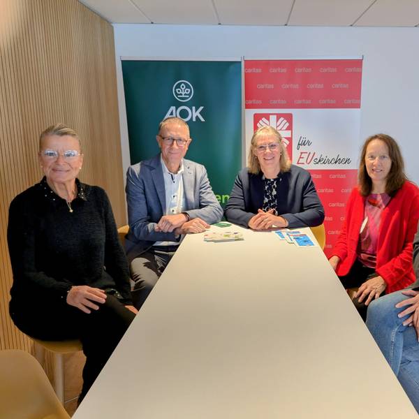Berit Lamche-Fortouna (AOK), Helmut Schneider (Regionaldirektor AOK Bonn/Rhein-Sieg-Kreis/Euskirchen), Maria Surges-Brilon (Caritas), Dorothee Koch (Diplompädagogin) und Gianna Winkle (Sozialpädagogin) sitzen um einen Tisch.